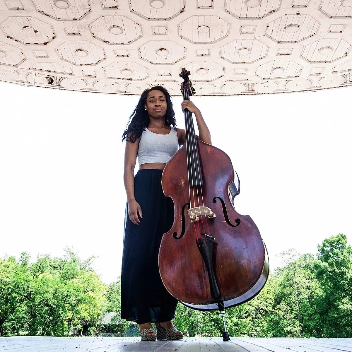 A woman standing and holding an upright bass