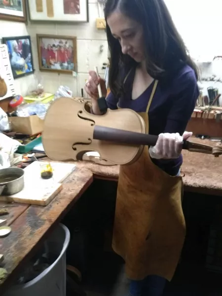 Goins working on a violin at Mr. Humble’s shop