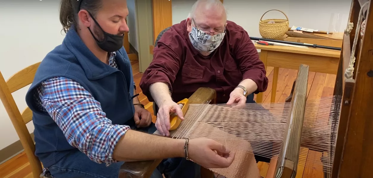 Bob Young teaches Anthony Carter his first lesson on the loom