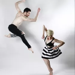 Two partnered dancers dress in black and white