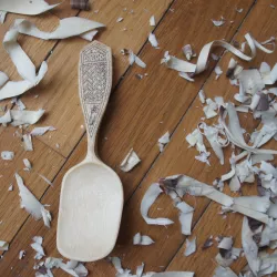 Carved wooden spoon and wood shavings